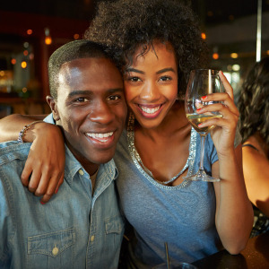Couple smiling and woman holding a wine glass
