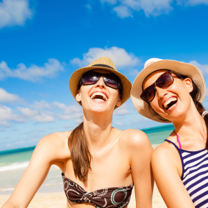 two women on a beach laughing