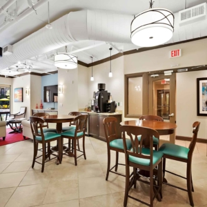 Bistro tables and coffee area in resident clubhouse looking into sitting area overlooking the pool