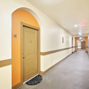 Corridors at Visconti with apartment number signs and bright paint highlighting the door of each home
