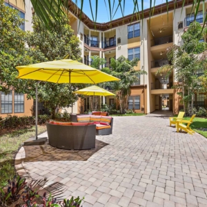 Courtyard with lounge patio furniture covered by bright yellow umbrellas