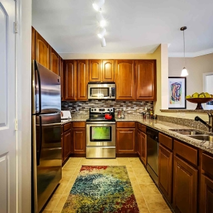 Kitchen in 2 bedroom model of Visconti with stainless steel appliances, granite counters, and pendant lighting